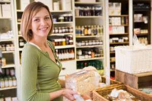 Woman in market looking at bread smiling